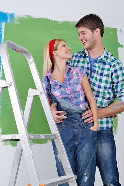 istock happy couple paint wall at new home 466127631