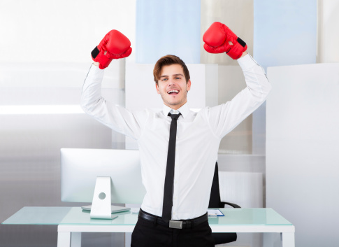 Portrait Of A Successful Businessman Wearing Red Boxing Gloves In Office