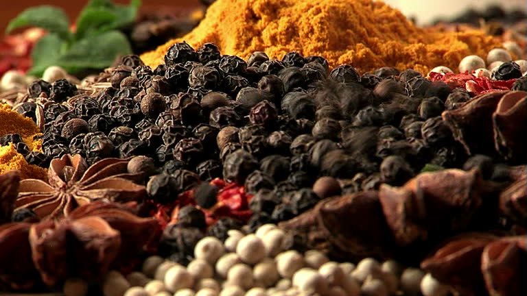 Pours black pepper peas. Mixing spices.