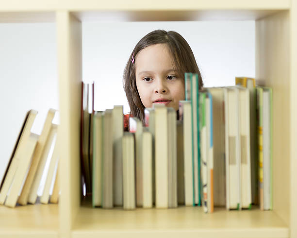 istock Young girl looking at books on bookshelf 466130038