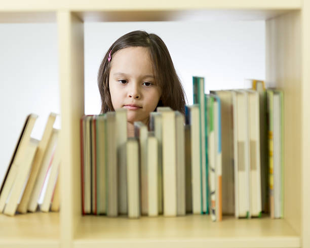 istock Young girl looking at books on bookshelf 466130054