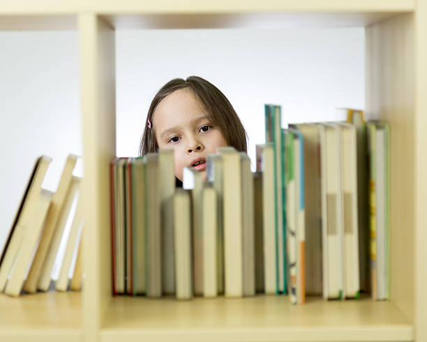 istock Young girl looking at books on bookshelf 466130070