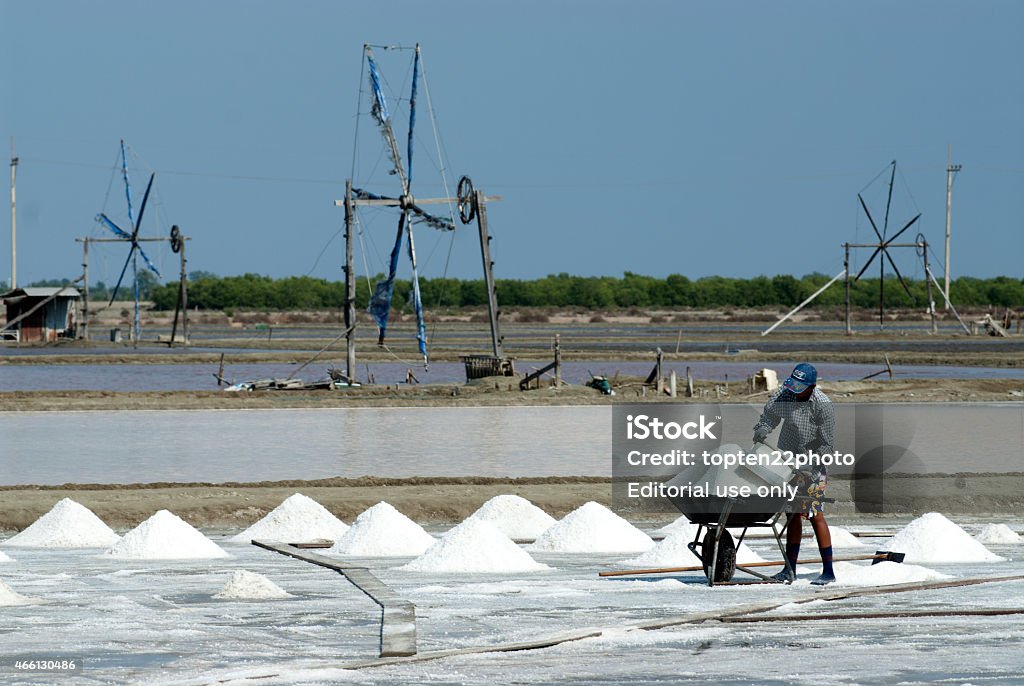 Workers are working at a salt farm in Thailand. Samutsongkhram,Thailand - February 18,2014: Unidentified workers carrying salt at the salt farm on February 18,2014 in Samutsongkhram Province,Thailand.Salt production is one of the main industries in Thailand. 2015 Stock Photo