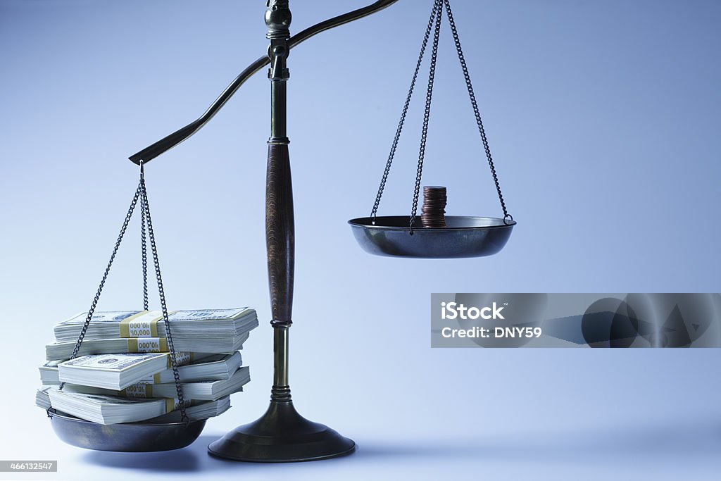 Income Inequality A stack of cash and a stack of pennies on a scale. Weight Scale Stock Photo