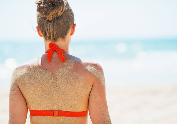 istock young woman on beach. rear view 466137019