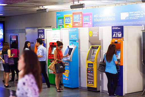 Bangkok, Thailand - March 6, 2015: Capture of Thai peope ate rainbow colored ATMs in subway station Sukhumvit in Bangkok. Dofferent colored ATMs of different banks.