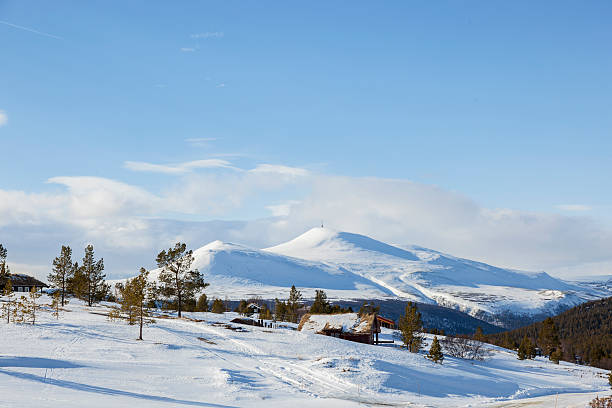 Norwegian mountainous landscape with cabins in winter. Hovringen, Ronda National Park. View to the mountain Jetta  1617 meters above sea level.