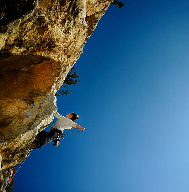 istock climber climbing on a rock with  negative slope. 466143960