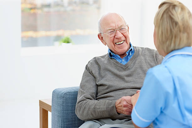 istock Happy elderly patient talking with nurse at home 466144095