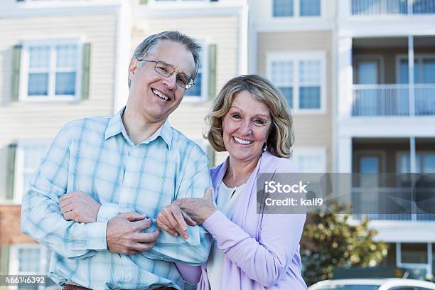 Mature Couple In Front Of Apartment Building Stock Photo - Download Image Now - 2015, 50-59 Years, 60-69 Years