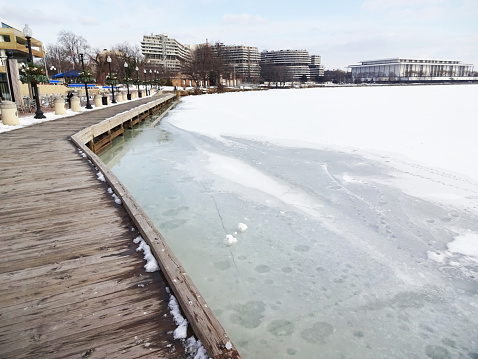 Photo of the frozen Potomac at the Georgetown Waterfront in Washington DC during February.  Watergate complex and John F. Kennedy Center are in the background.