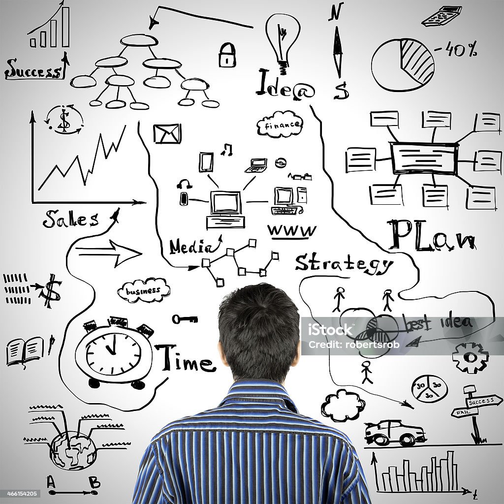 A man contemplating business decisions Businessman looking om the wall hand draw business sketches over grey background Abstract Stock Photo
