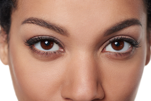 Cropped closeup image of breathtaking female brown eyes staring at you