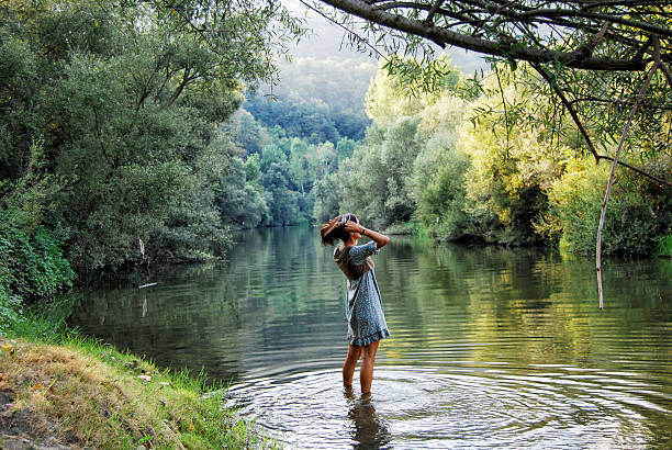 Young woman playing with water in lake