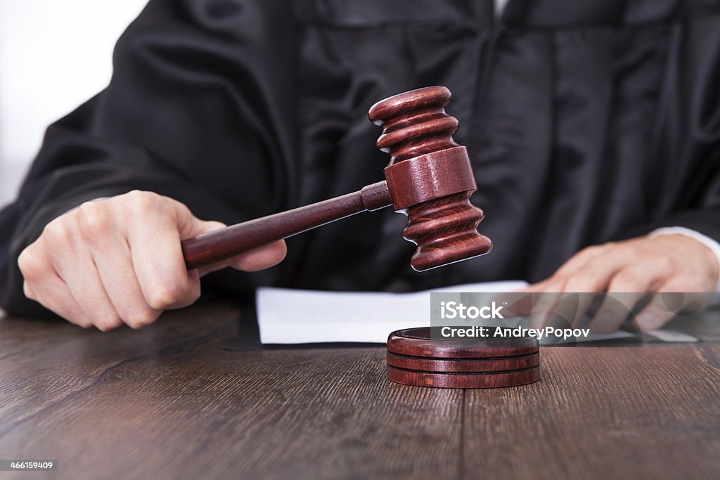 Judge Holding Mallet Close-up Of A Judge Hitting Mallet At Desk Judge - Law Stock Photo