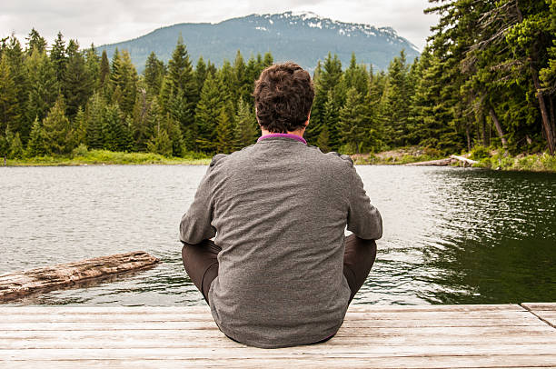 istock Young man meditating at a lake 466159913
