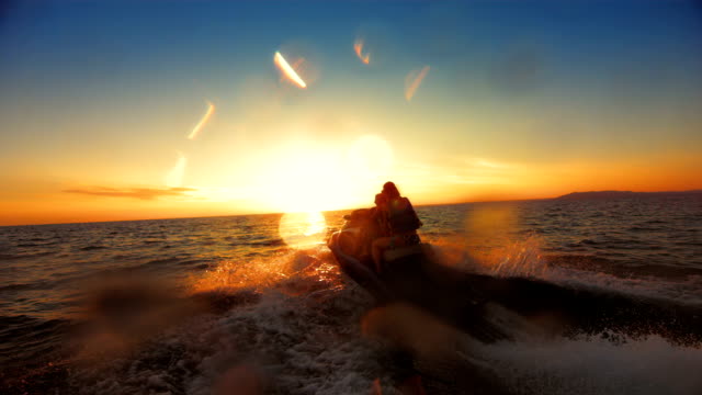 SLO MO Family Riding A Jet Boat At Sunset