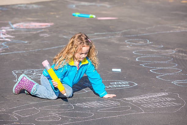 istock Young Girl Drawing With Chalk on Blacktop 466160882