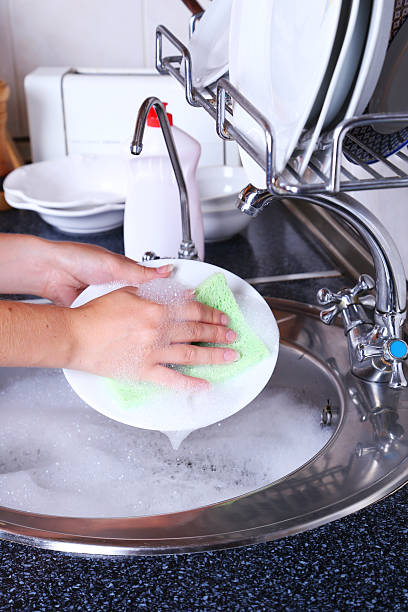 istock Female hand with sponge washing dish 466160942