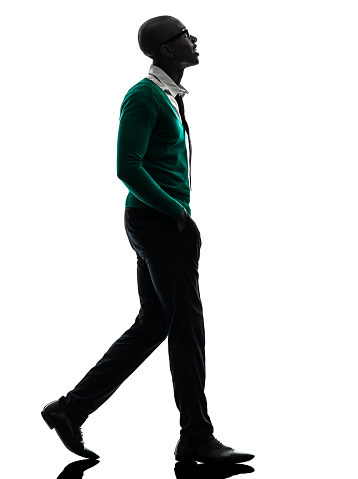 one african black man walking looking up in silhouette studio on white background