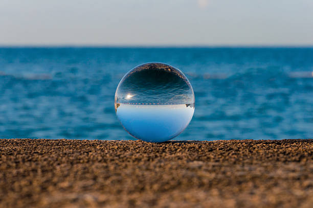 istock Glass transparent ball on sea background and grainy surface. Water 466171764