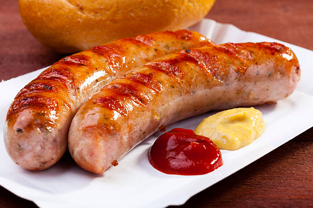 salchichas a la parrilla con pan se sirve en una bandeja de papel - sausage bratwurst barbecue grill barbecue fotografías e imágenes de stock