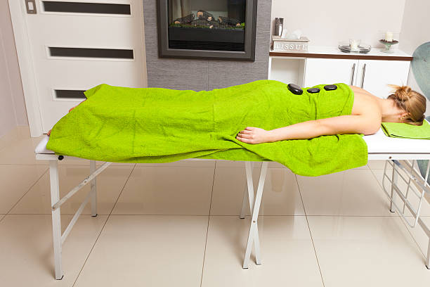salão de beleza.  mulher recebendo massagem spa terapia com pedras quentes - massage therapist stone spa treatment working - fotografias e filmes do acervo