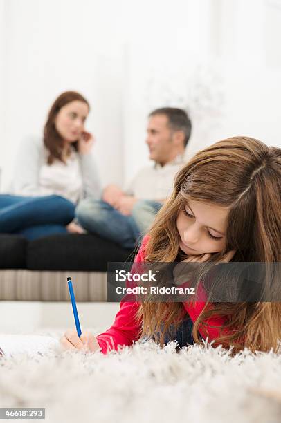 Girl Doing Homework Lying On Carpet Stock Photo - Download Image Now - Adult, Cheerful, Child