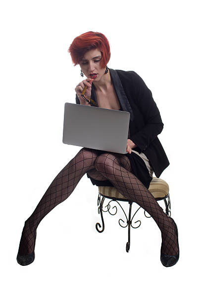 Red haired stylish business executive sitting with modern laptop stock photo