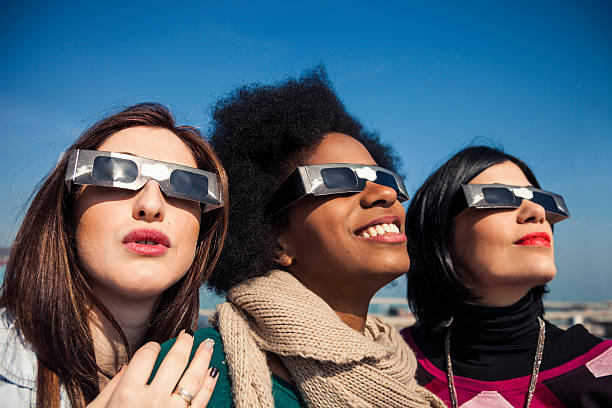 istock Group of friends looking to a solar eclipse 466186744