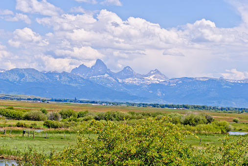 The Teton river in the foreground and the Mountains in the distance.  Farming in the middle.