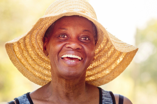 Close-up of happy senior African American woman in hat.