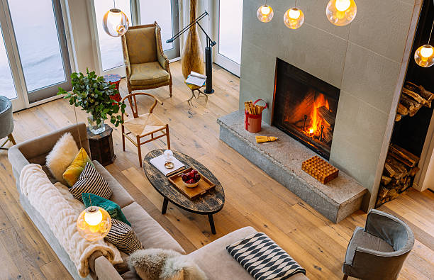 Collingwood Cottage Open Concept Interior North American Cottage interior. Main floor open area of winter home North of Toronto, Canada. Featuring large windows with view of surrounding area, grand fireplace, modern mix of furniture and fabrics from around the world. modern cottage interior design stock pictures, royalty-free photos & images