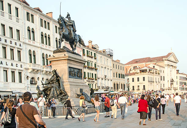 A large group of tourists along the Grand Canal near St. Mark's Square.
