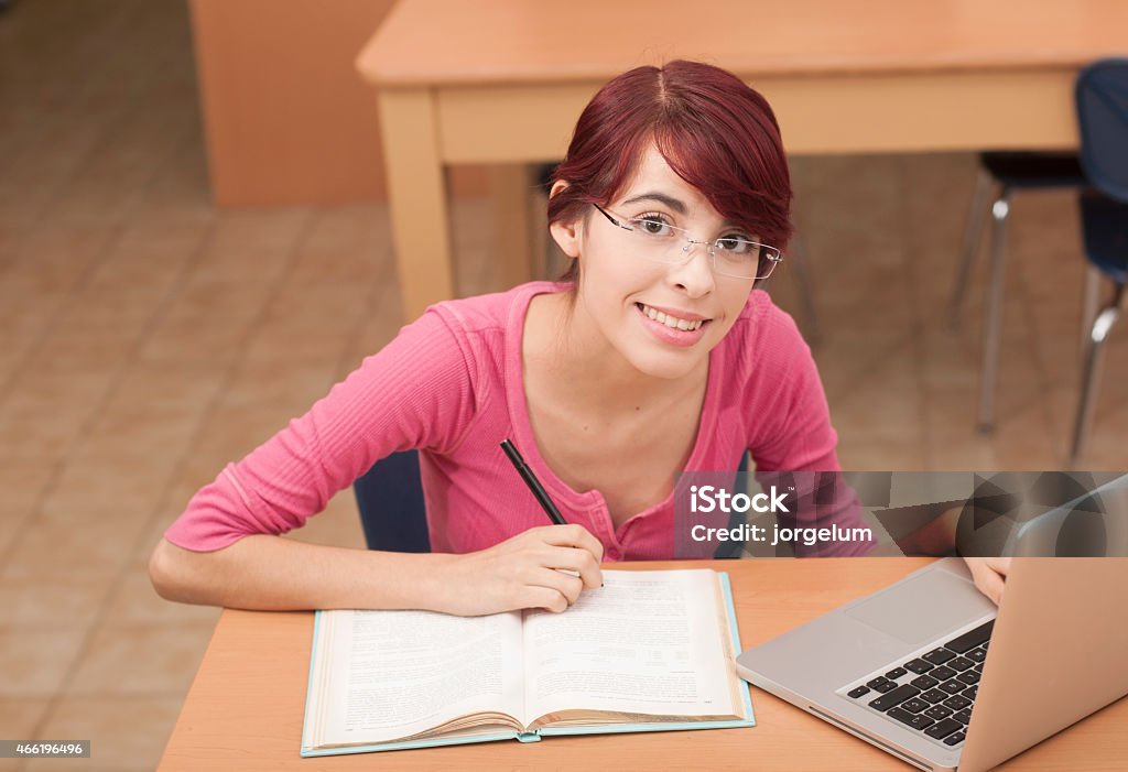 Teen Doing Homework in the library Beautiful smiling in college library 2015 Stock Photo