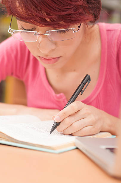 istock Beautiful woman studying in the library 466196508