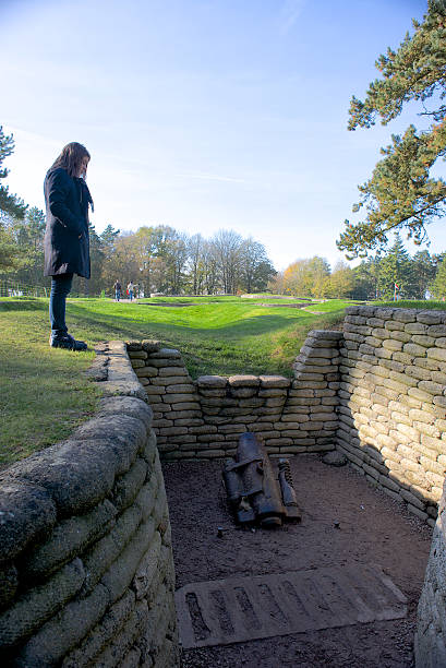 World War One trenches, Vimy Ridge, France Vimy Ridge, France - November 11, 2014: A visitor to the Canadian War Memorial at Vimy Ridge, France, looking down at a mortar located in the trenches, preserved from World War One vimy memorial stock pictures, royalty-free photos & images