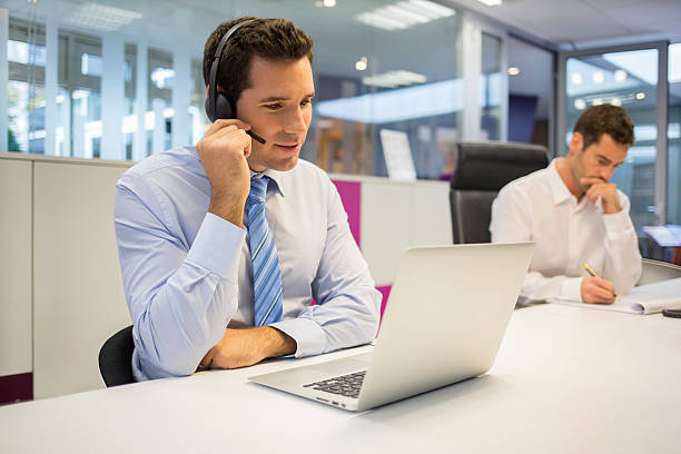 Businessman at office on the phone with headset, Skype