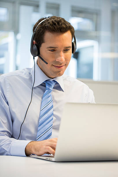 istock Businessman wearing headset at office on phone using Skype 466197645