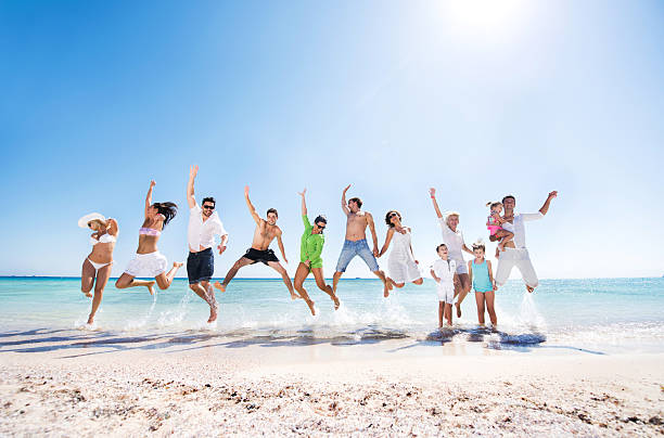 istock Large group of cheerful people jumping on the beach. 466201486