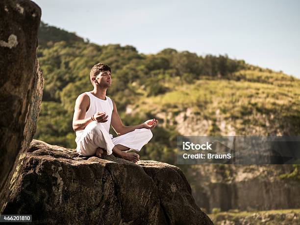 Young Latin American Man Meditating On A Rock Stock Photo - Download Image Now - 2015, Adult, Adults Only