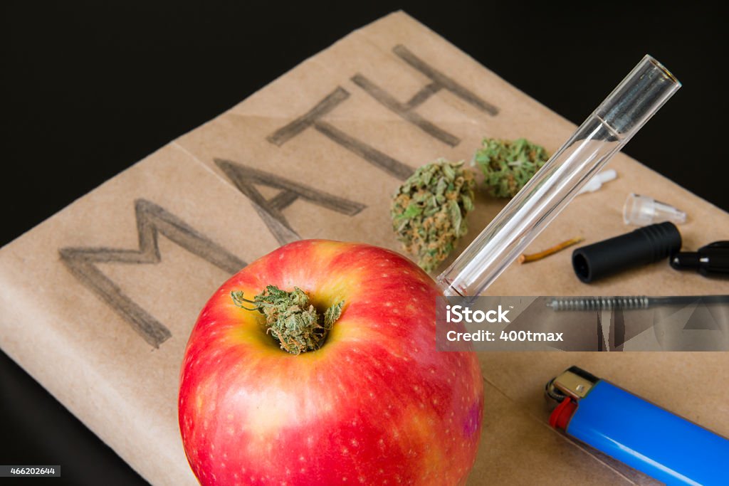 Drugs in School An apple bong and marijuana lying on a math book. Bong Stock Photo