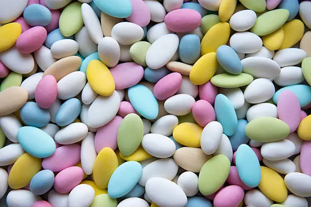 Background of sugared almonds color blue, rose, green, yellow, beige and white.