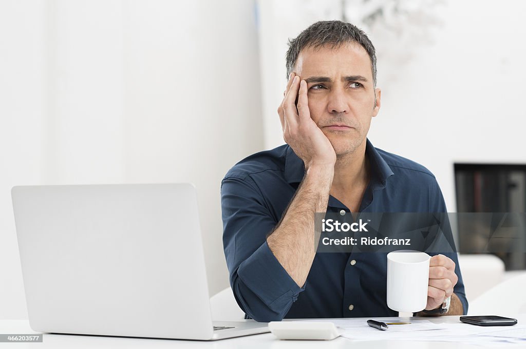 Unhappy Man At The Desk Portrait Of A Worried Mature Man With Laptop Holding Cup Men Stock Photo