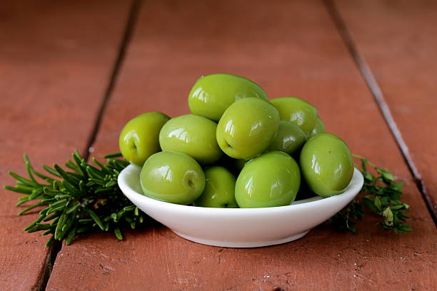 istock green marinated olives in bowl on a wooden table 466204091