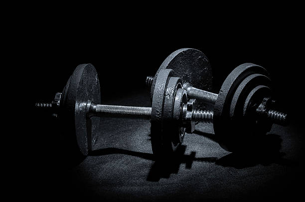 istock dumbbells gym equipment black and white image, isolated on black 466206500