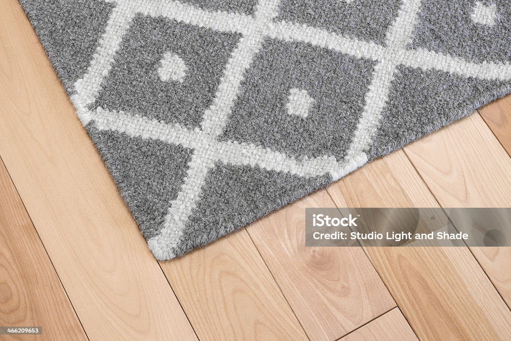 Gray rug on wooden floor Contemporary gray wool rug on wooden floor. Rug Stock Photo