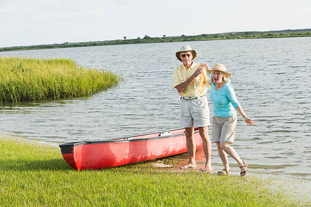 coppia senior, divertirsi con canoa - canoeing canoe senior adult couple foto e immagini stock