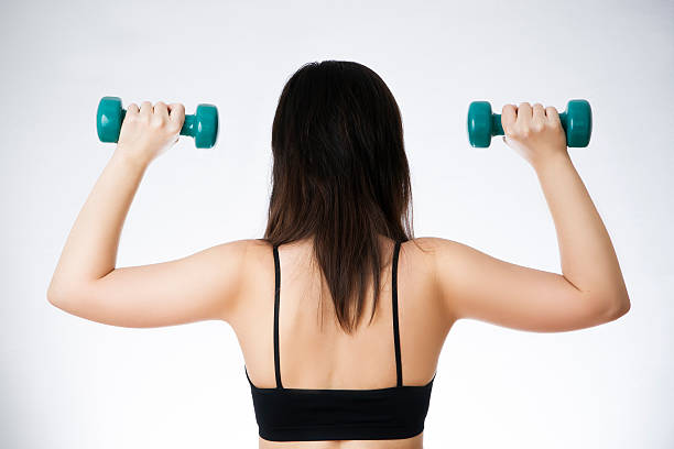istock Young woman doing exercises with dumbbells 466211732