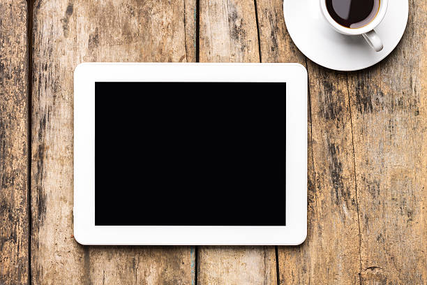 istock Tablet with a cup of coffee on a wooden table 466212236